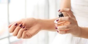 Mulher passando perfume no pulso