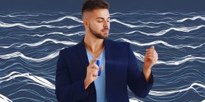 Homem de blazer azul escuro se perfumando