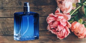Um frasco de perfume masculino ao lado de rosas