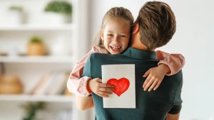 Homem segurando filha pequena no colo