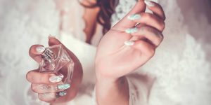 Mãos femininas com um frasco de perfume