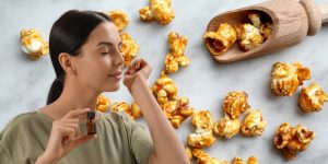 Mulher sentindo o perfume no próprio pulso; ao fundo, uma montagem com pipocas caramelizadas