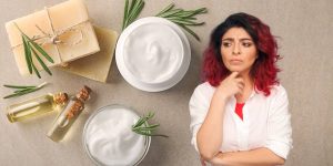 Montagem com cremes distribuídos sobre uma superfície plana e uma mulher com expressão de dúvida em destaque