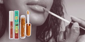 Close no rosto de mulher passando gloss e duas opções de gloss marrom ao lado