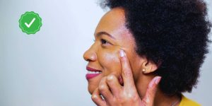 Mulher passando pomada no canto do olho